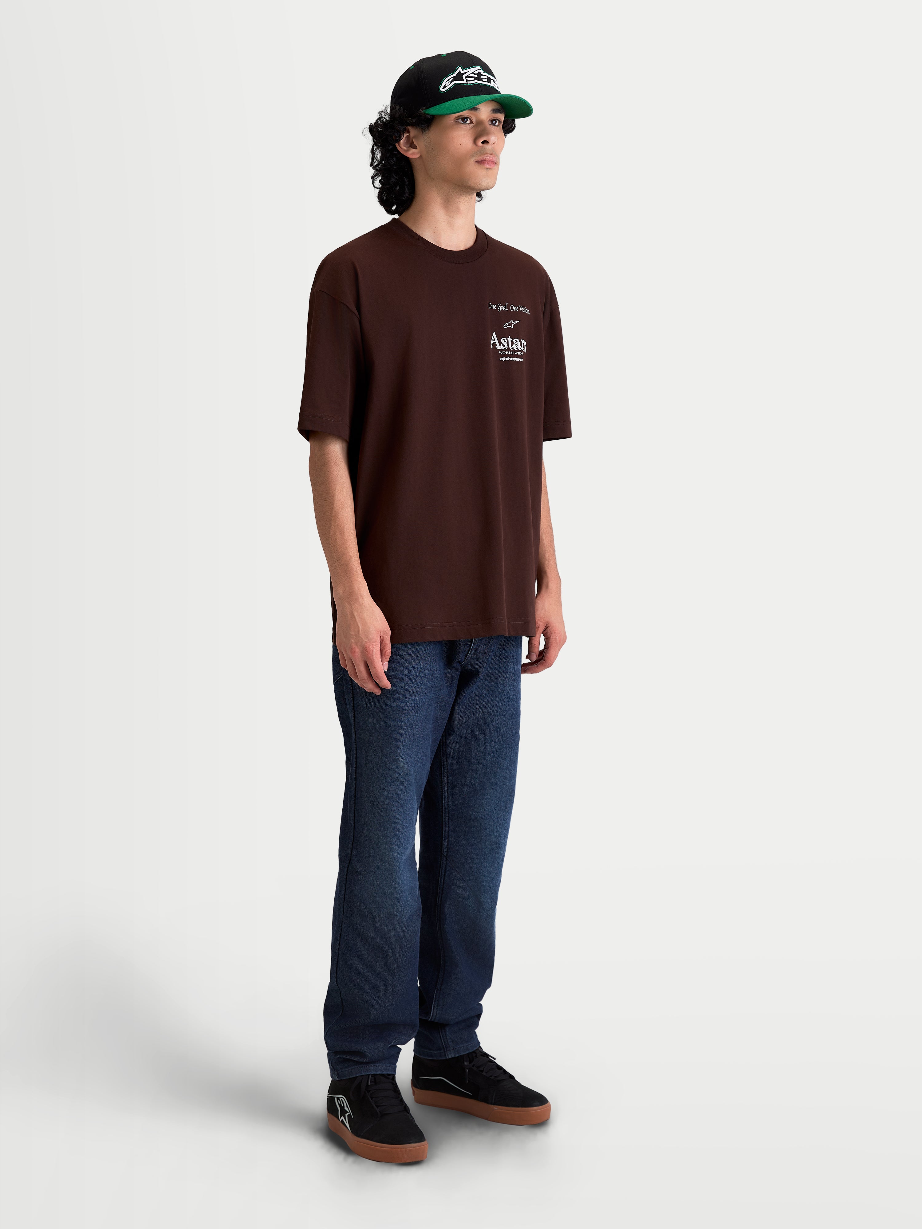 Alpinestars Post Oversized CSF T-Shirt, braunes Herren-Sportswear-T-Shirt, Kurzarm, lockere Oversized-Passform, mit weißer Astars-Wortlogo-Grafik auf der Brust, hochwertiges Baumwoll-Mischgewebe, am Model getragen.