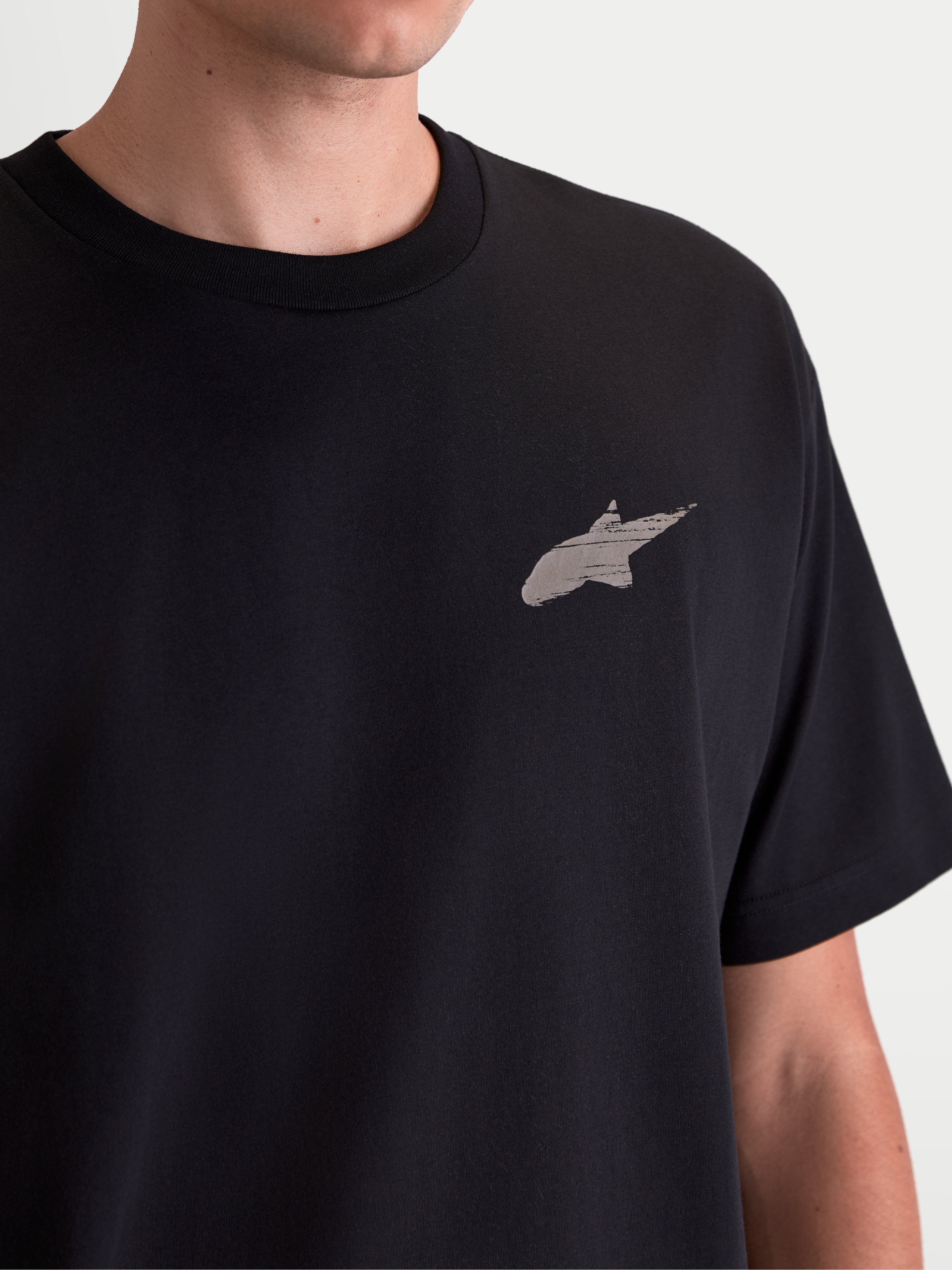 Alpinestars Checkback Oversized CSF T-Shirt, Kurzarm-Sportswear-T-Shirt, Unisex, Schwarz, Baumwoll-Polyester-Mischgewebe, Detailansicht der Vorderseite mit Astars-Logo und Soft-Hand-Print-Finish, lässiger Motorsport-Stil.
