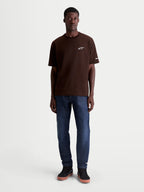 Alpinestars Mandate Oversized CSF T-Shirt, Kurzarm, Sportswear für Herren, Braun und Weiß, entspannte Oversized-Passform, Astars Logo-Puffdruck auf der Brust, Baumwoll-Polyester-Mischung, lässige Lifestyle-Bekleidung am Modell.