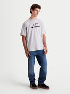 Alpinestars Prelude Oversized CSF T-Shirt, lässiges Kurzarm-Sportswear-T-Shirt am Modell, Grau (Cement) mit schwarzem, gestapeltem Astars-Logo auf der Brust, lockere Oversized-Passform aus Baumwoll-Polyester-Mischgewebe für täglichen Komfort.