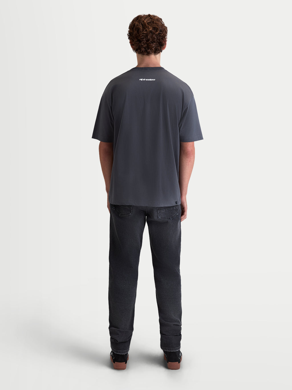 Alpinestars Prelude Oversized CSF T-Shirt, Herren-Sportswear-T-Shirt, Kurzarm, Grau, mit kleinem weißem Logo am oberen Rücken, locker sitzende Oversized-Passform, weicher Baumwoll-Polyester-Mix, Rückansicht am Modell.