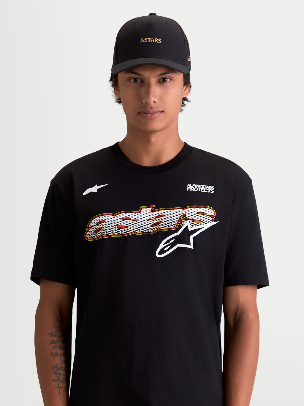 Alpinestars Cypress CSF T-Shirt, Herren-Kurzarm-Sportswear-T-Shirt in Schwarz und Weiß, mit Astars-Grafik mit Mesh-Füllung und Alpinestars Protects-Logo, Lifestyle-Ansicht am Modell, hochwertige Baumwoll-Polyester-Mischung.