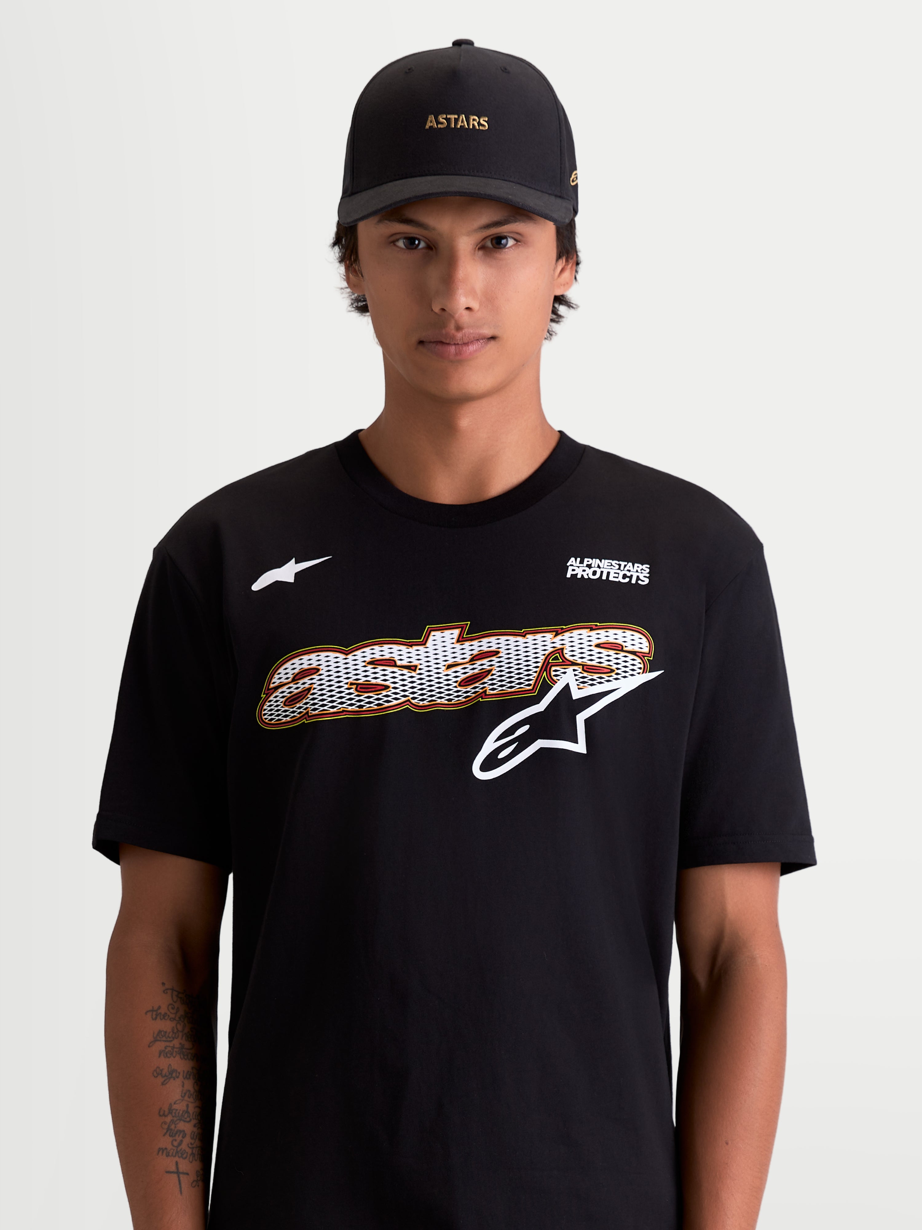 Alpinestars Cypress CSF T-Shirt, Herren-Kurzarm-Sportswear-T-Shirt in Schwarz und Weiß, mit Astars-Grafik mit Mesh-Füllung und Alpinestars Protects-Logo, Lifestyle-Ansicht am Modell, hochwertige Baumwoll-Polyester-Mischung.
