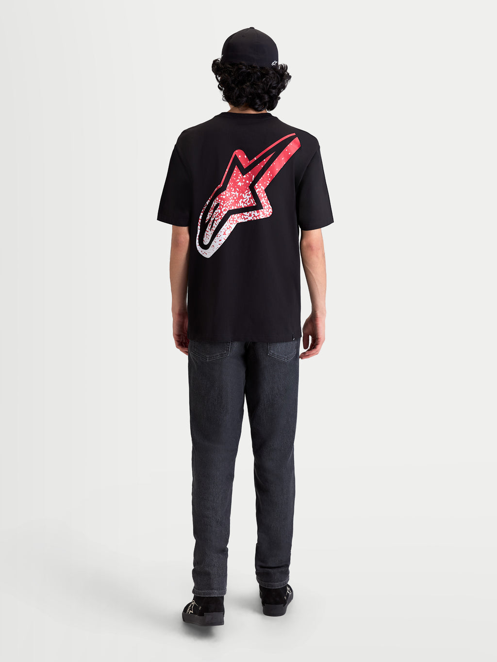 Alpinestars Meteor CSF T-Shirt, Kurzarm-Sportswear-T-Shirt, Schwarz, Rot und Weiß. Rückansicht am Modell mit großem Astars-Logo auf dem Rücken und MX-inspiriertem rot-weißem Farbverlauf.