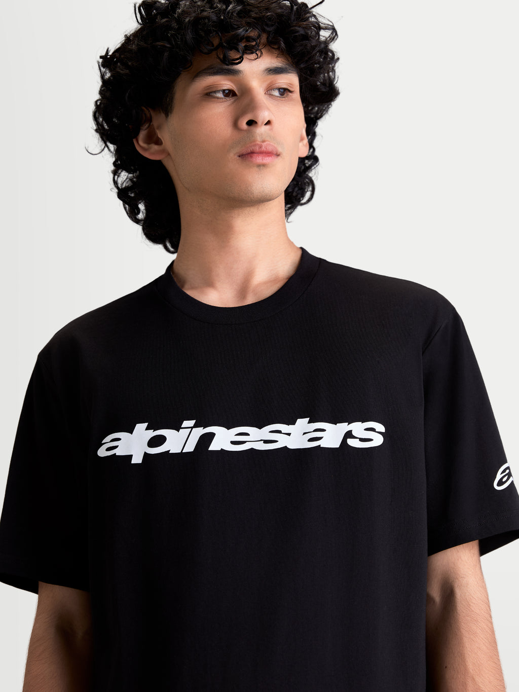 Alpinestars Race Wordmark CSF T-Shirt, lässiges Sportswear-T-Shirt am Modell, Schwarz und Weiß, mit markanter Wordmark-Grafik auf der Brust und Ageless-Logo am Ärmel, Baumwoll-Polyester-Mischung für hohen Tragekomfort im Alltag.