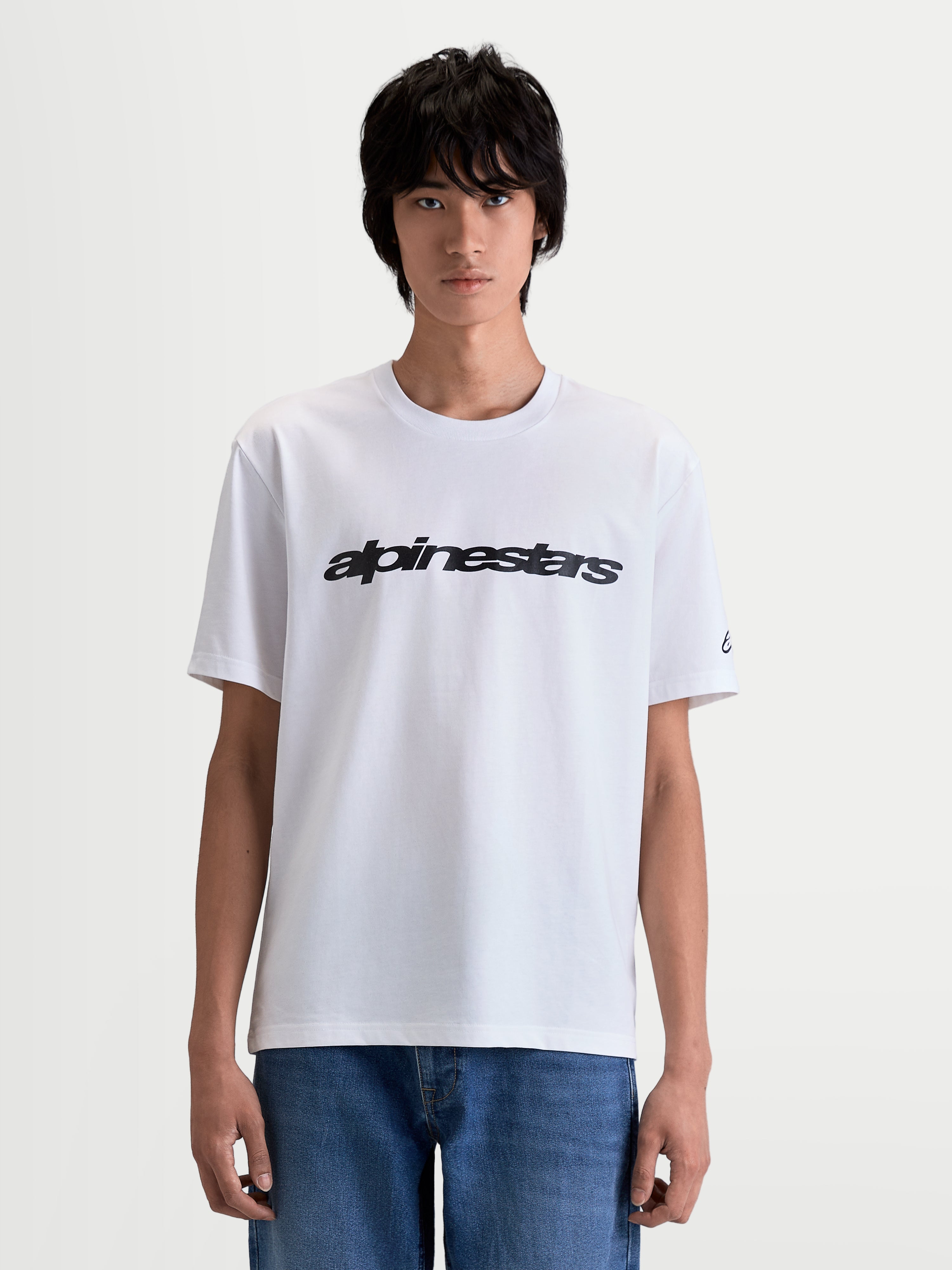 Alpinestars Race Wordmark CSF T-Shirt, Kurzarm-Sportswear-T-Shirt, Weiß und Schwarz, mit markanter Motorsport-Wortmarke und Ärmellogo, aus einer Premium-Baumwoll-Polyester-Mischung, Vorderansicht am Modell.