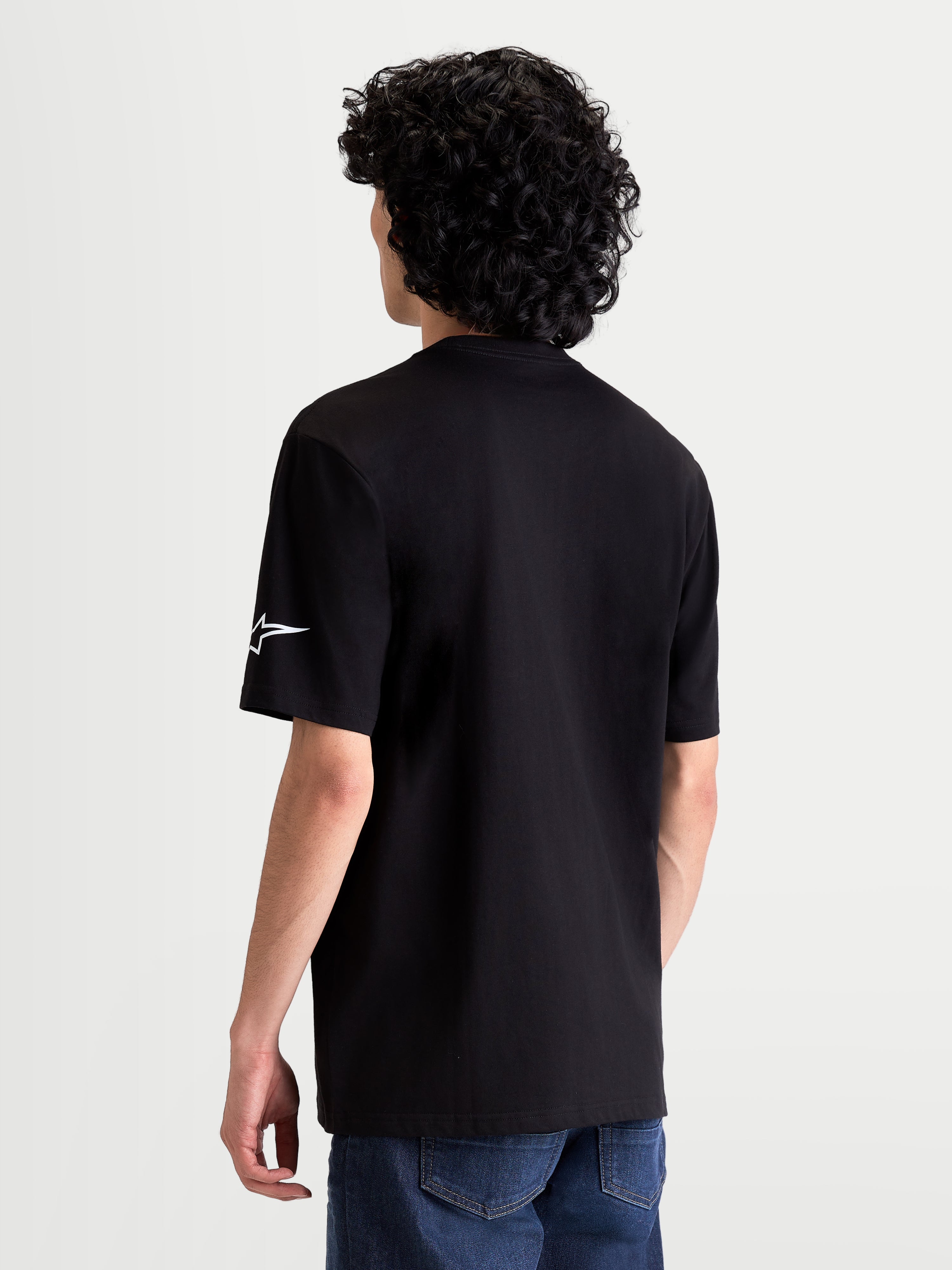 Alpinestars Race Wordmark CSF T-Shirt, lässiges Kurzarm-T-Shirt, Schwarz mit weißem Ageless-Logo am Ärmel, Rückansicht am Modell, Motorsport-inspirierte Bekleidung.