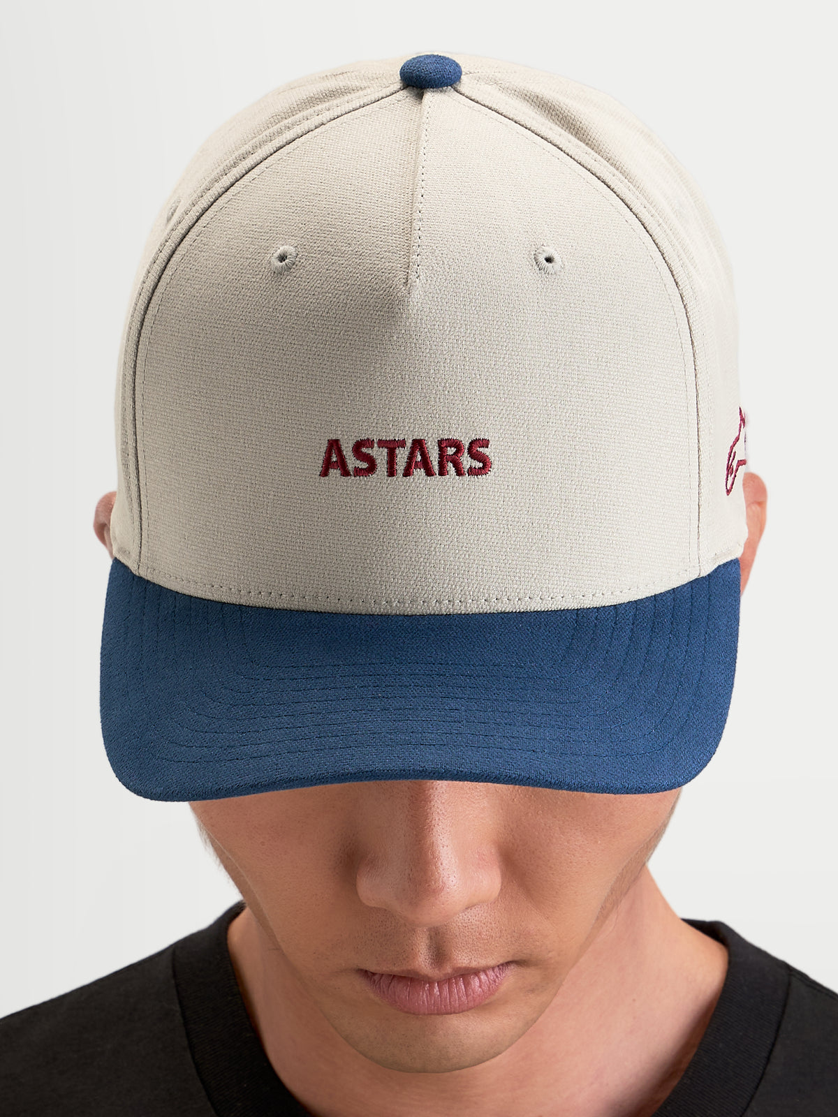 Alpinestars County Canvas Kappe, Sportswear-Kappe in Sand und Blau, gebogener Schirm, strukturierte Krone mit Astars-Stickerei vorne, getragen von einem Model