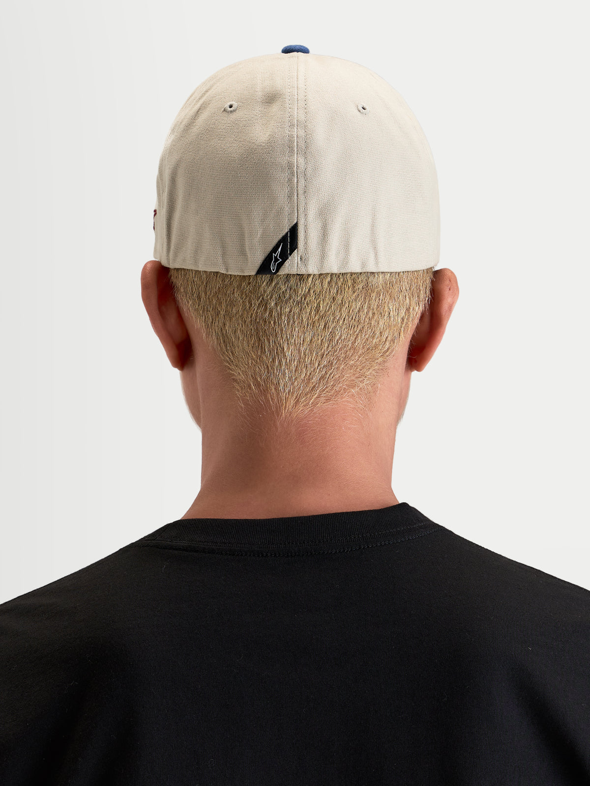 Alpinestars County Canvas Kappe, lässige Sportswear-Kappe in Sand und Blau, Rückansicht an einem Model mit Flex-Rückseite und dezentem Rückenlabel-Branding aus Oxford-Baumwollgewebe