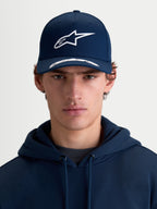 Alpinestars Arclight Kappe, Sportswear-Kappe mit gebogenem Schirm, Blau und Weiß, Vorderansicht am Modell, mit strukturierter Krone, strukturiertem Astars-Logo im Puff-Druck und hochwertigem Baumwolltwill.
