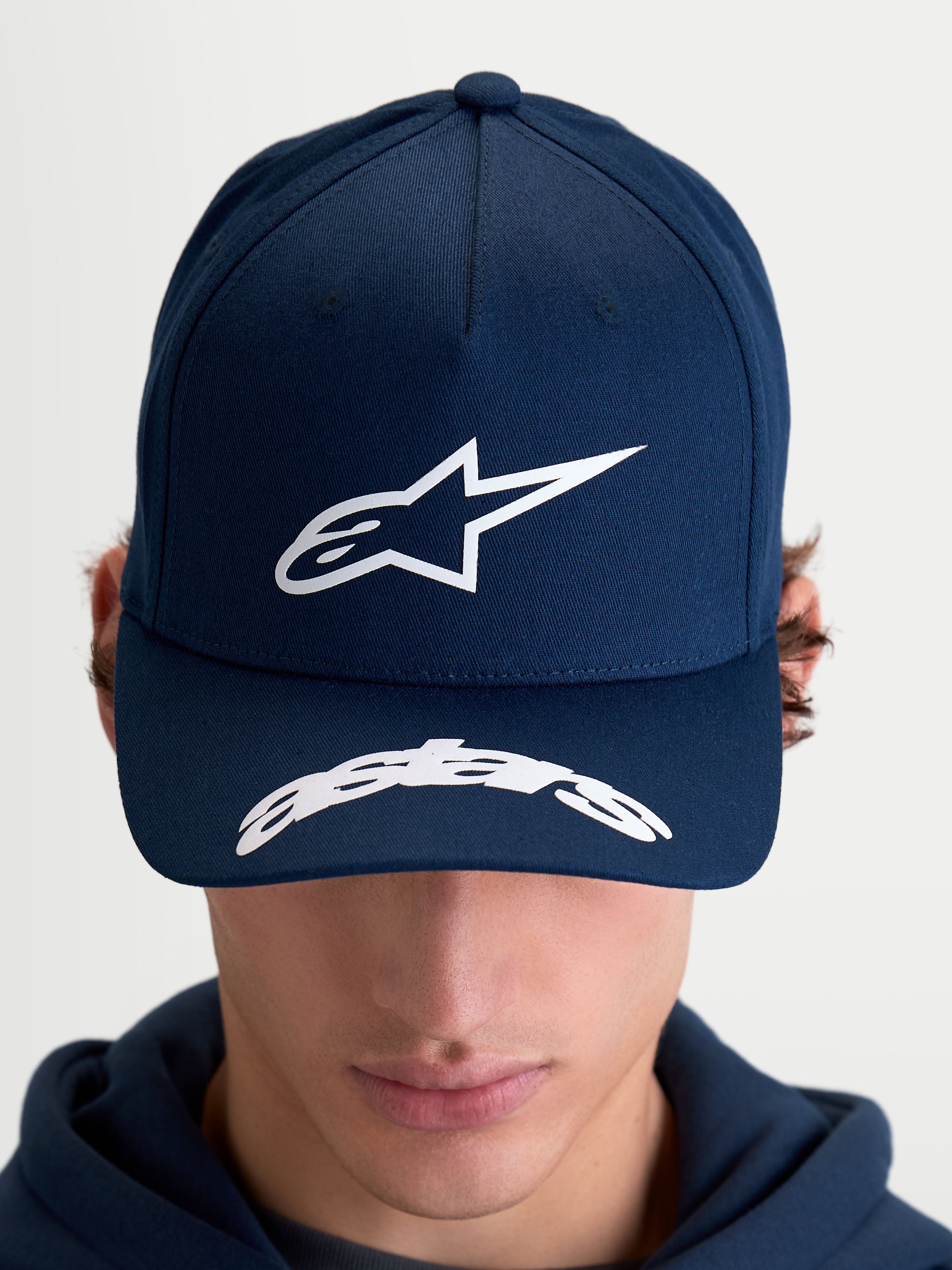 Alpinestars Arclight Kappe, Motorsport-inspirierte Sportswear Baseball-Kappe für Herren und Damen, Blau (Navy) und Weiß, mit strukturierter Krone, Puff-Print Astars-Logo, gebogenem Schirm mit Astars-Wortmarke und strapazierfähiger Baumwolltwill-Konstruktion, Frontansicht am Modell.