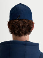 Alpinestars Arclight Kappe, Unisex Sportswear Baseball-Kappe, Navy-Blau, strapazierfähiger Baumwoll-Twill mit Flex-Rückseite, Rückansicht am Model zeigt charakteristisches Astars-Logo-Etikett.