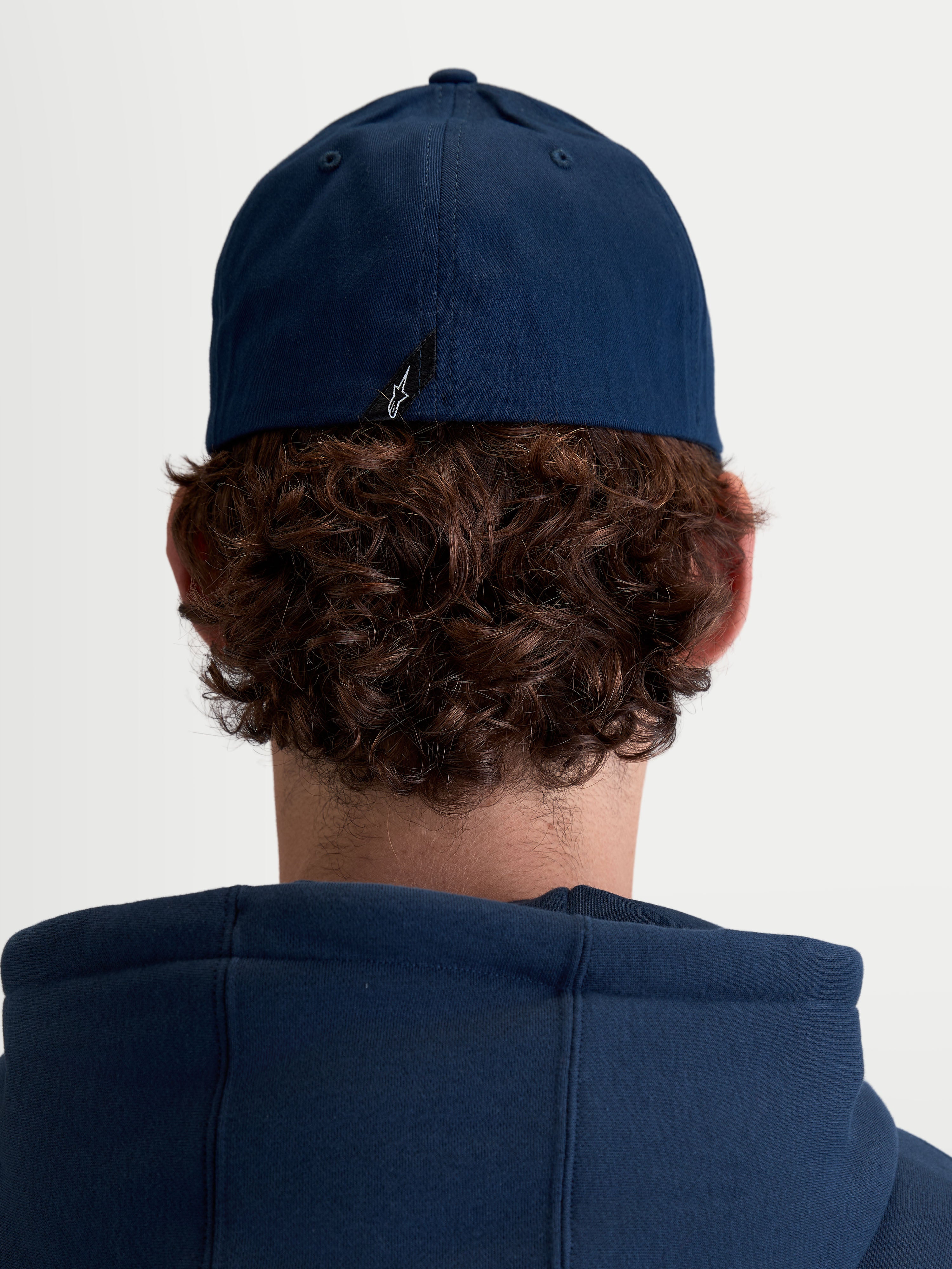 Alpinestars Arclight Kappe, Unisex Sportswear Baseball-Kappe, Navy-Blau, strapazierfähiger Baumwoll-Twill mit Flex-Rückseite, Rückansicht am Model zeigt charakteristisches Astars-Logo-Etikett.