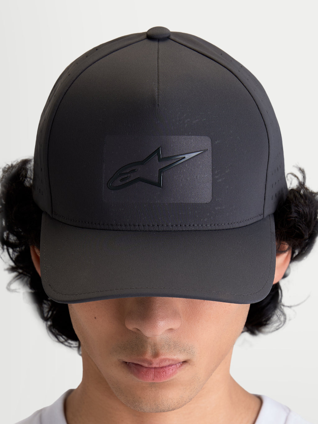 Alpinestars Algo Perf Adjustable Kappe, Sportswear-Baseballkappe, Dunkelgrau, mit strukturierter Krone, gebogenem Schirm und Sonic-Weld Astars-Logo, atmungsaktive seitliche Perforationen, hochwertige Motorsport-Kopfbedeckung, Vorderansicht am Modell.