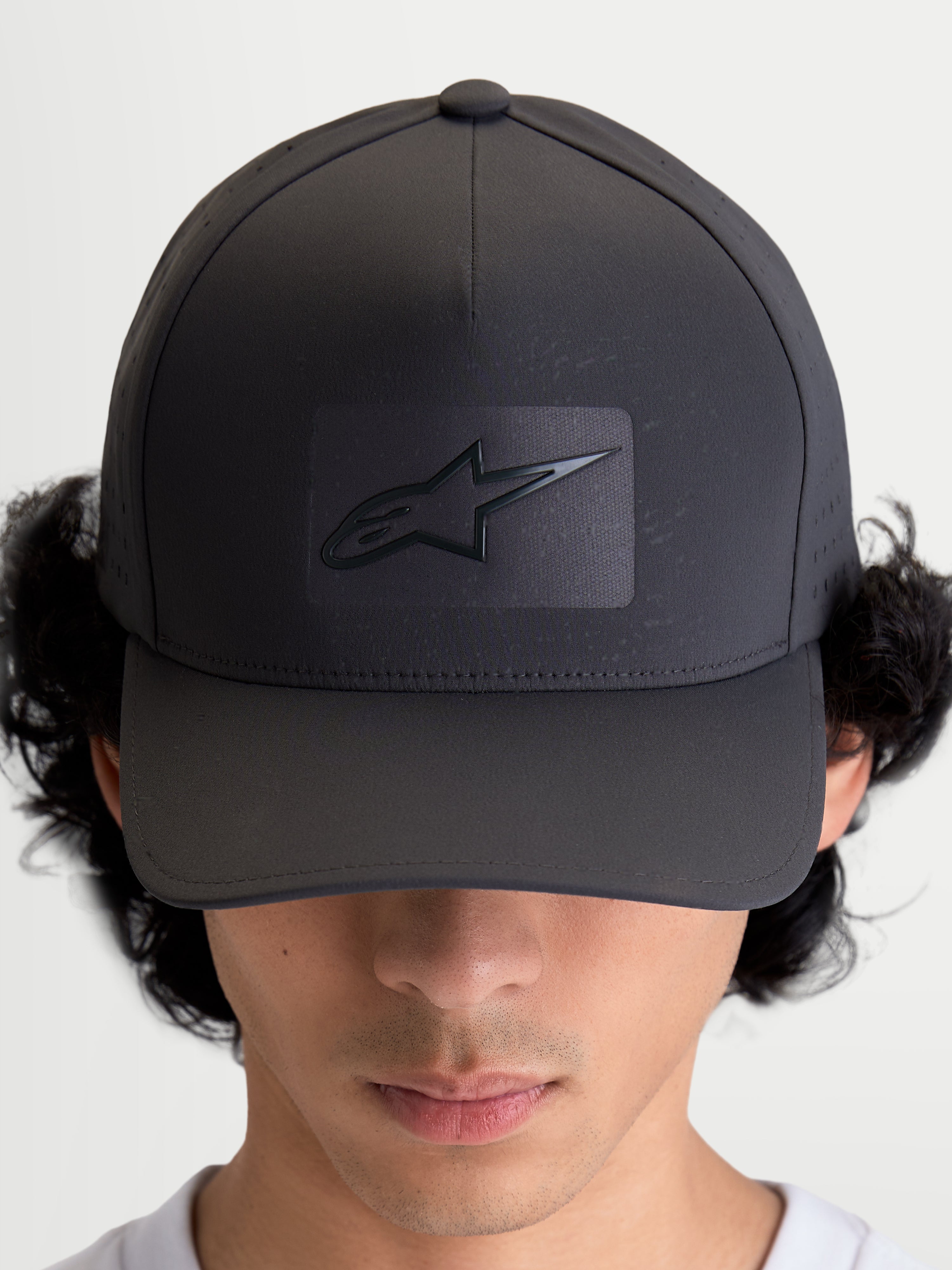Alpinestars Algo Perf Adjustable Kappe, Sportswear-Baseballkappe, Dunkelgrau, mit strukturierter Krone, gebogenem Schirm und Sonic-Weld Astars-Logo, atmungsaktive seitliche Perforationen, hochwertige Motorsport-Kopfbedeckung, Vorderansicht am Modell.