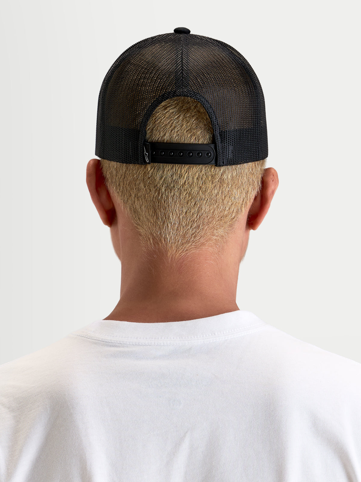 Alpinestars Hemmings Trucker-Kappe, schwarze Sportswear-Snapback-Kappe, Rückansicht mit atmungsaktivem Poly-Mesh-Einsatz und verstellbarem Verschluss am Model
