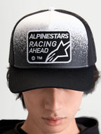 Alpinestars Gravel Trucker-Kappe, Sportswear Trucker-Cap für Damen und Herren, Schwarz und Weiß, mit gewebtem Alpinestars Racing Ahead Patch, Kieselstruktur-Details, strukturierter Krone und gebogenem Schirm, Frontansicht am Modell.