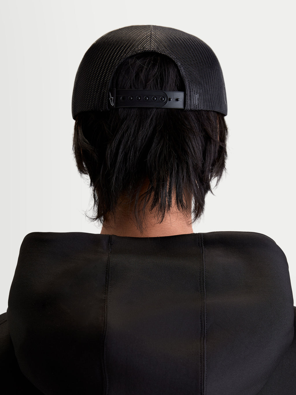Alpinestars Gravel Trucker-Kappe, Sportswear Snapback-Cap, Unisex, Schwarz, Rückansicht am Modell zeigt die atmungsaktive Poly-Mesh-Rückseite und den verstellbaren Snapback-Verschluss.