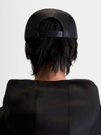 Alpinestars Gravel Trucker-Kappe, Sportswear Snapback-Cap, Unisex, Schwarz, Rückansicht am Modell zeigt die atmungsaktive Poly-Mesh-Rückseite und den verstellbaren Snapback-Verschluss.