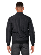 Alpinestars Precedent Jacke, Schwarz, Rückansicht am Modell, mit ikonischem schrägem Steppmuster, Rippbündchen und Saum, gestepptes F1-inspiriertes Motorsport-Design