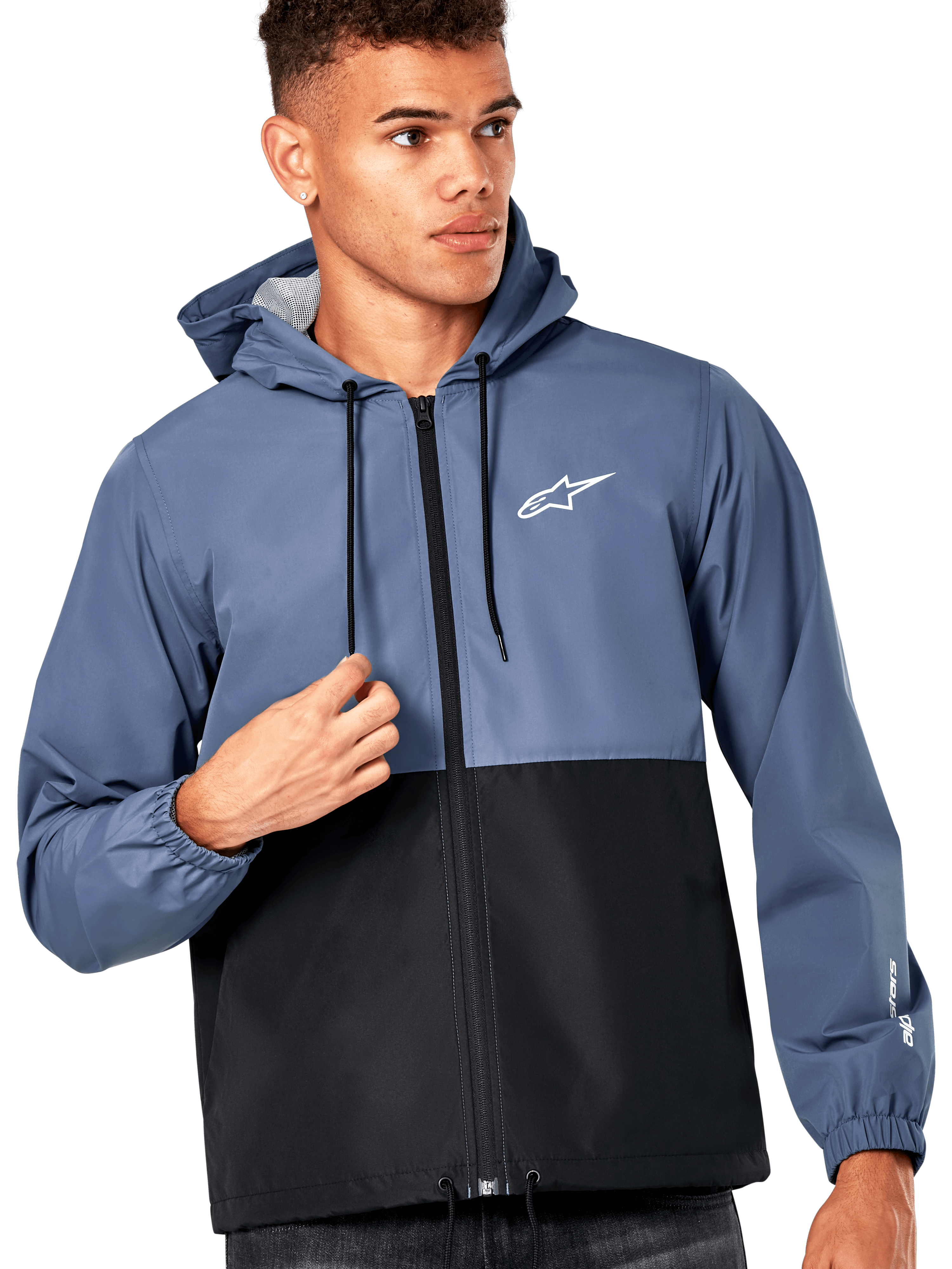 Männliches Model trägt die Alpinestars Speeder Windbreaker-Jacke, Farbblock-Design in Schieferblau und Schwarz, Kapuze mit schwarzen Kordelzügen, weißes Logo auf der Brust, lässiger, vom Motorsport inspirierter Windbreaker
