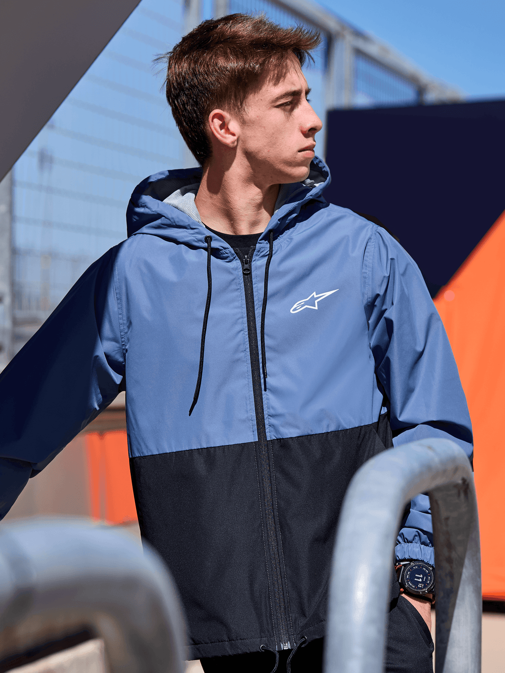 Alpinestars Speeder Windbreaker-Jacke, leichte Windbreaker-Jacke mit Kapuze, Colorblock-Design in Schieferblau und Schwarz, weißes Alpinestars-Logo auf der Brust, mit Mesh gefüttert, Kapuze mit Kordelzug, lässige, vom Motorsport inspirierte Streetwear