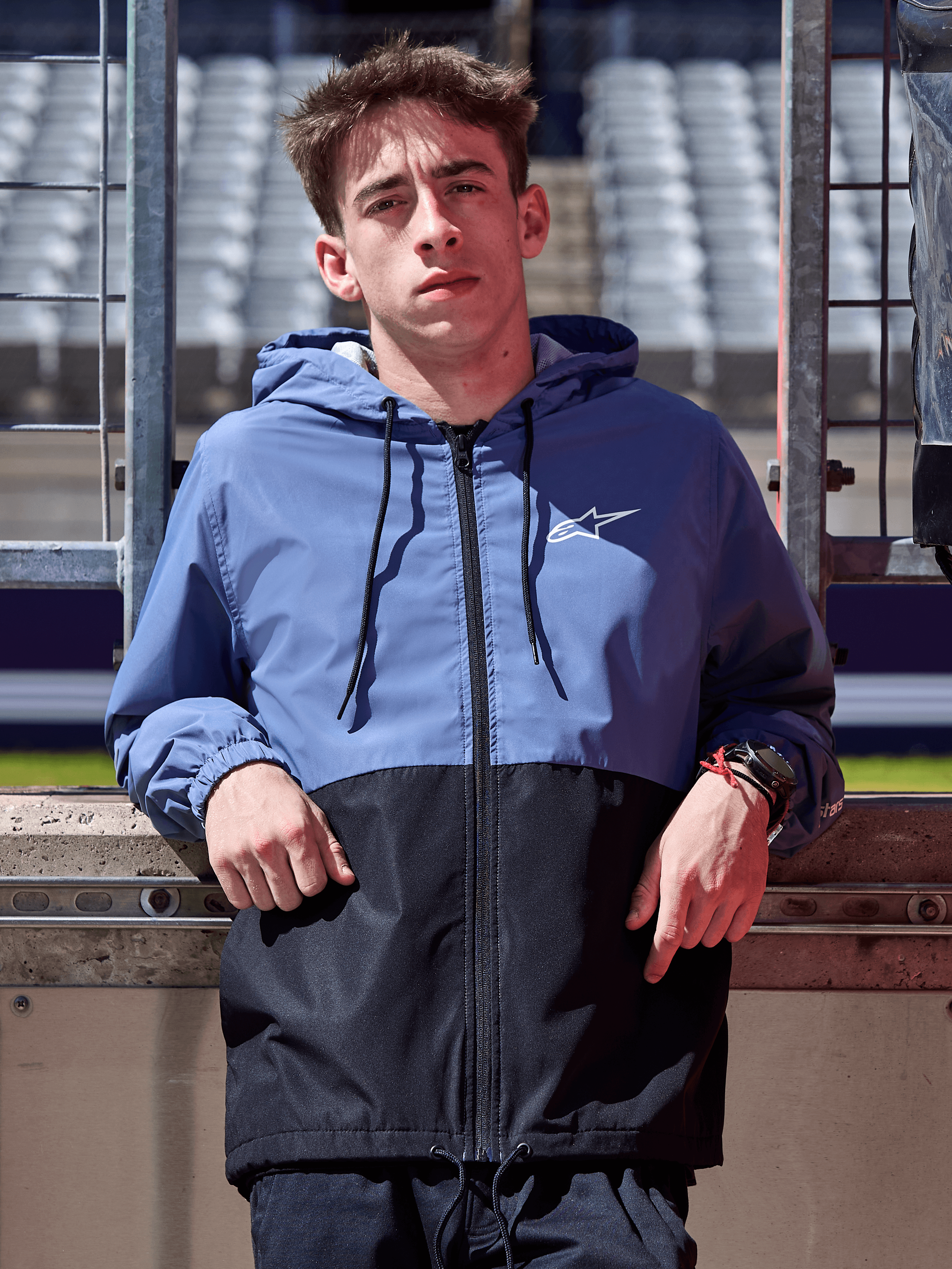 Alpinestars Speeder Windbreaker Jacke, Schieferblau und Schwarz, Kapuzen-Windbreaker im Block-Design, weißes Logo auf der Brust, lässige Lifestyle-Bekleidung an einer Rennstrecke