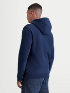 Alpinestars Ageless V3 Hoodie, Casual Sportswear-Kapuzenpullover, Navy-Blau, Rückansicht am Modell, mit Kapuze mit Eigenfutter, Rippbündchen und Saum, hochwertiges Mischgewebe aus Baumwolle und recyceltem Polyester.