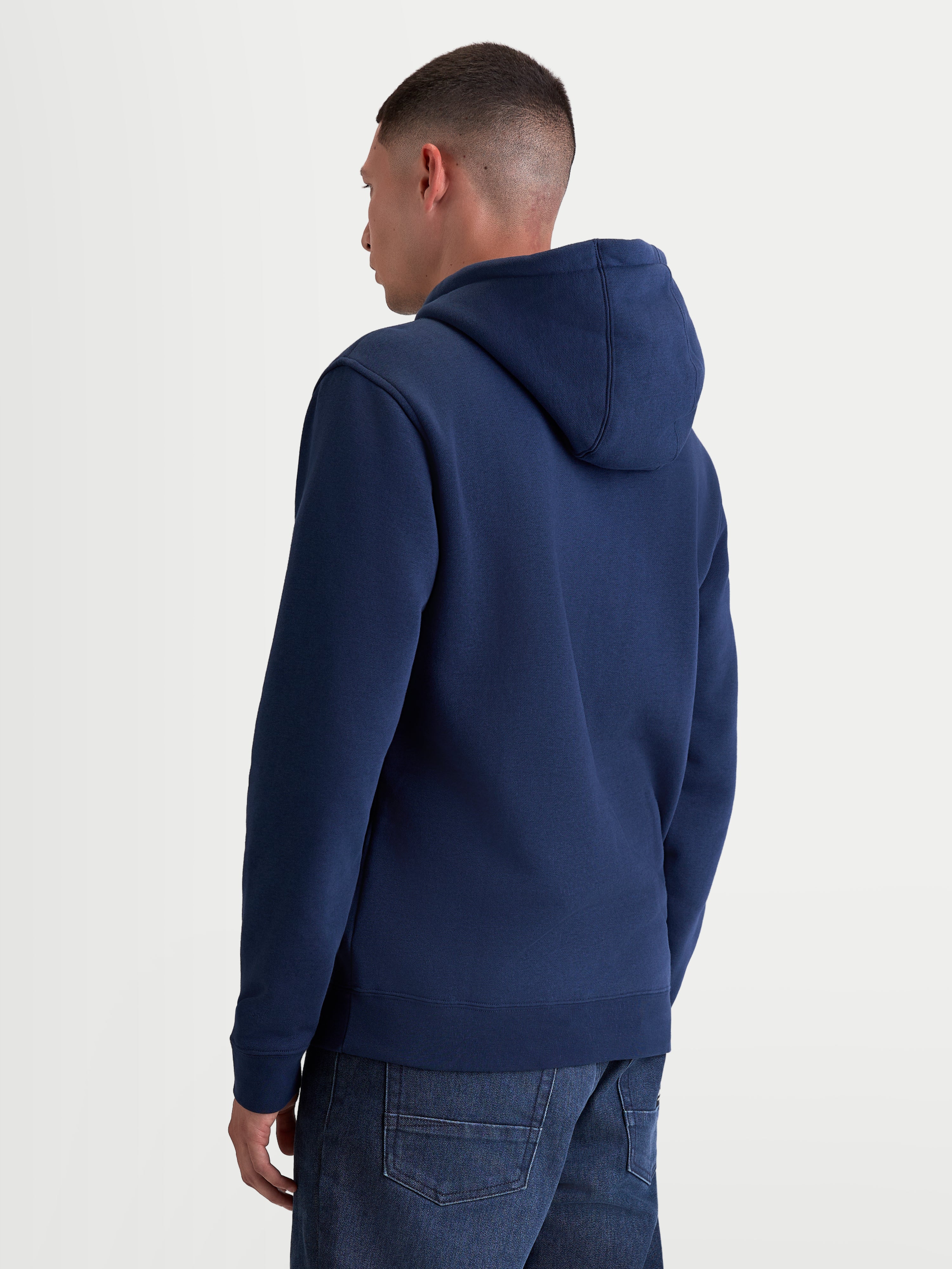 Alpinestars Ageless V3 Hoodie, Casual Sportswear-Kapuzenpullover, Navy-Blau, Rückansicht am Modell, mit Kapuze mit Eigenfutter, Rippbündchen und Saum, hochwertiges Mischgewebe aus Baumwolle und recyceltem Polyester.