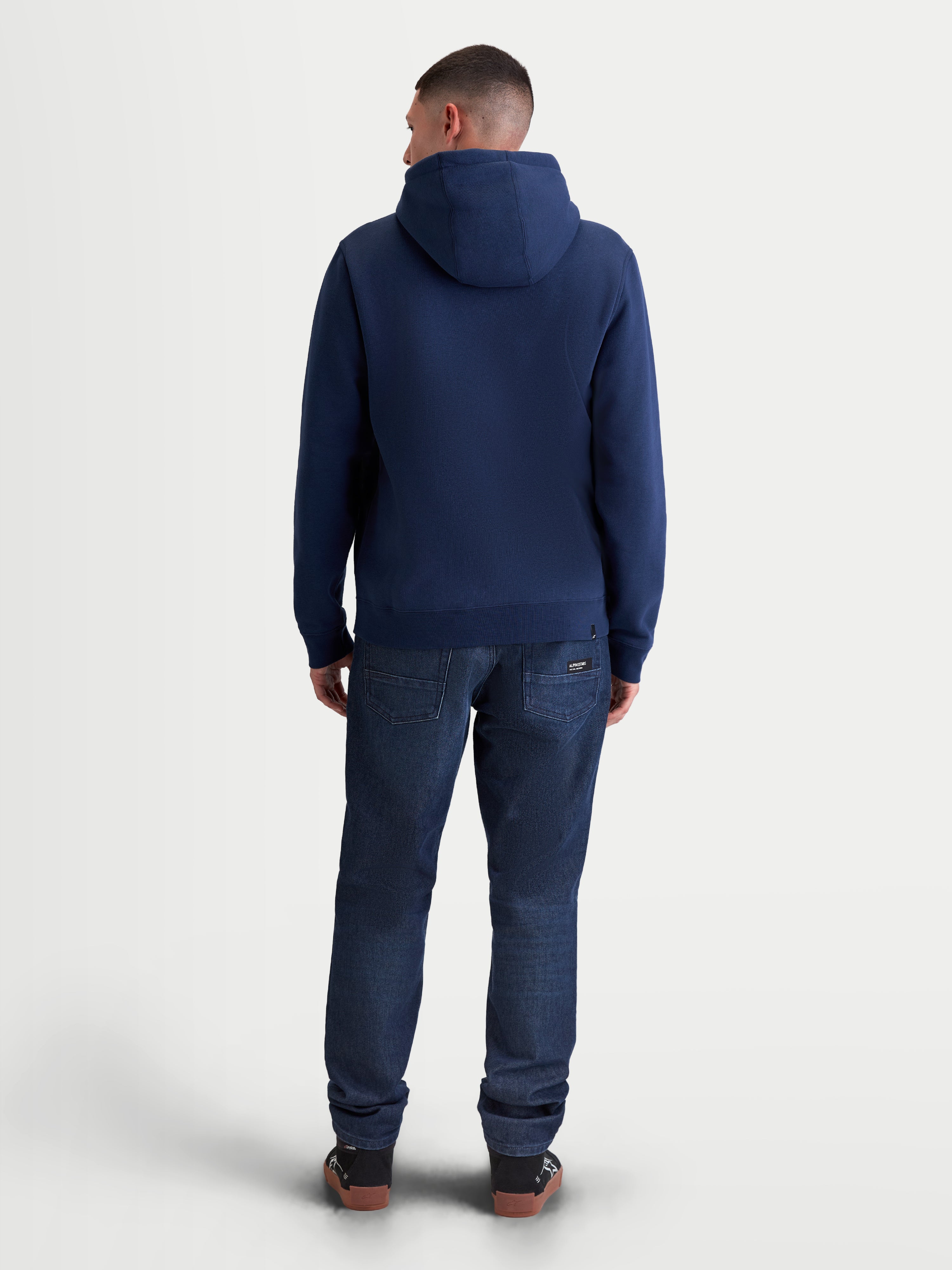 Alpinestars Ageless V3 Hoodie, Herren-Kapuzenpullover, Blau, weiches Fleece-Gewebe, vollständige Rückenansicht am Model, Motorsport-inspirierte Lifestyle-Bekleidung.