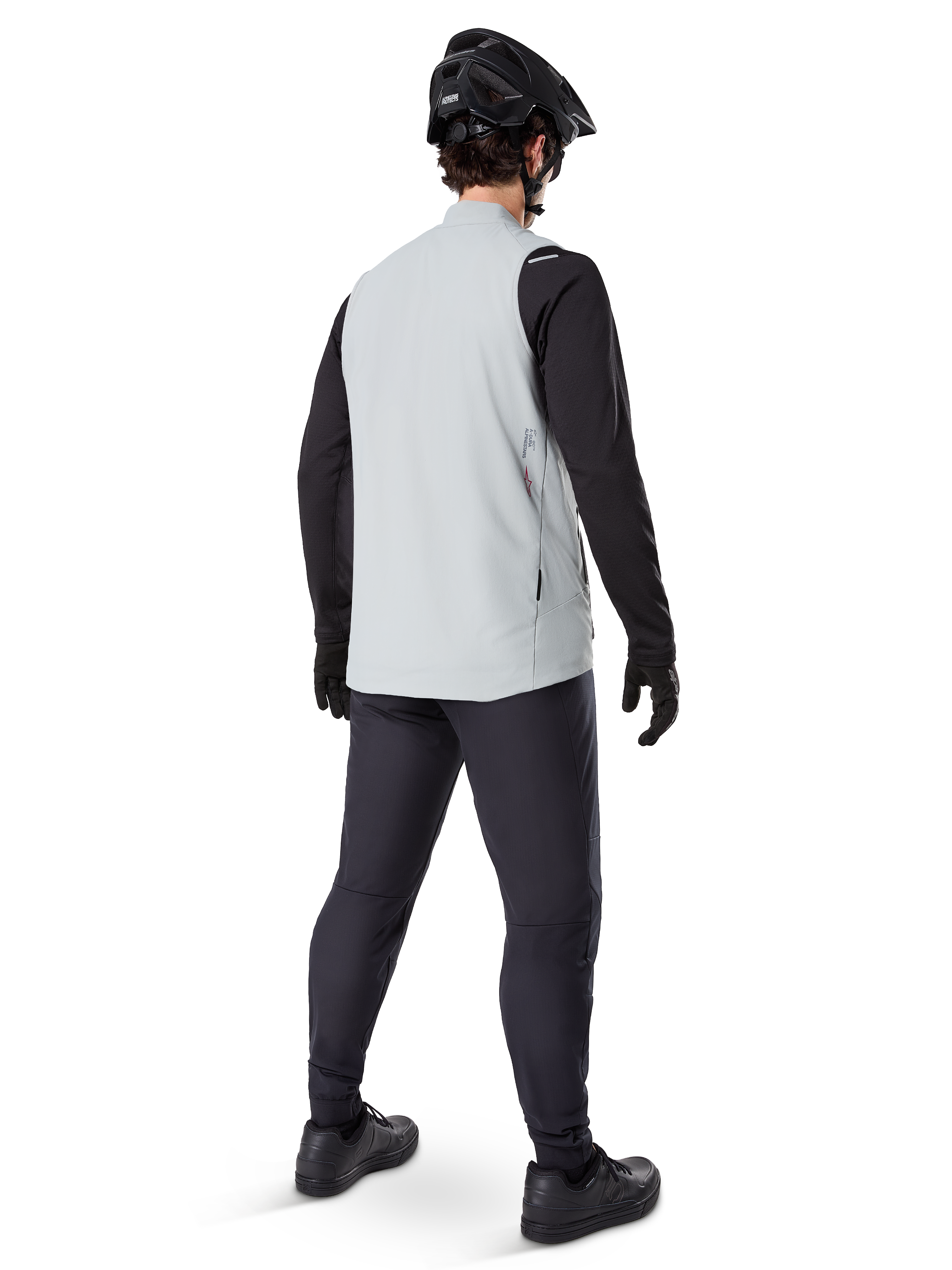 Alpinestars A-Dura Thermal Vest, Titanium Gray, rear view of model wearing the insulated cycling vest over a black long-sleeve top and dark pants, complete with a black mountain bike helmet and gloves, designed for cold-weather off-road riding