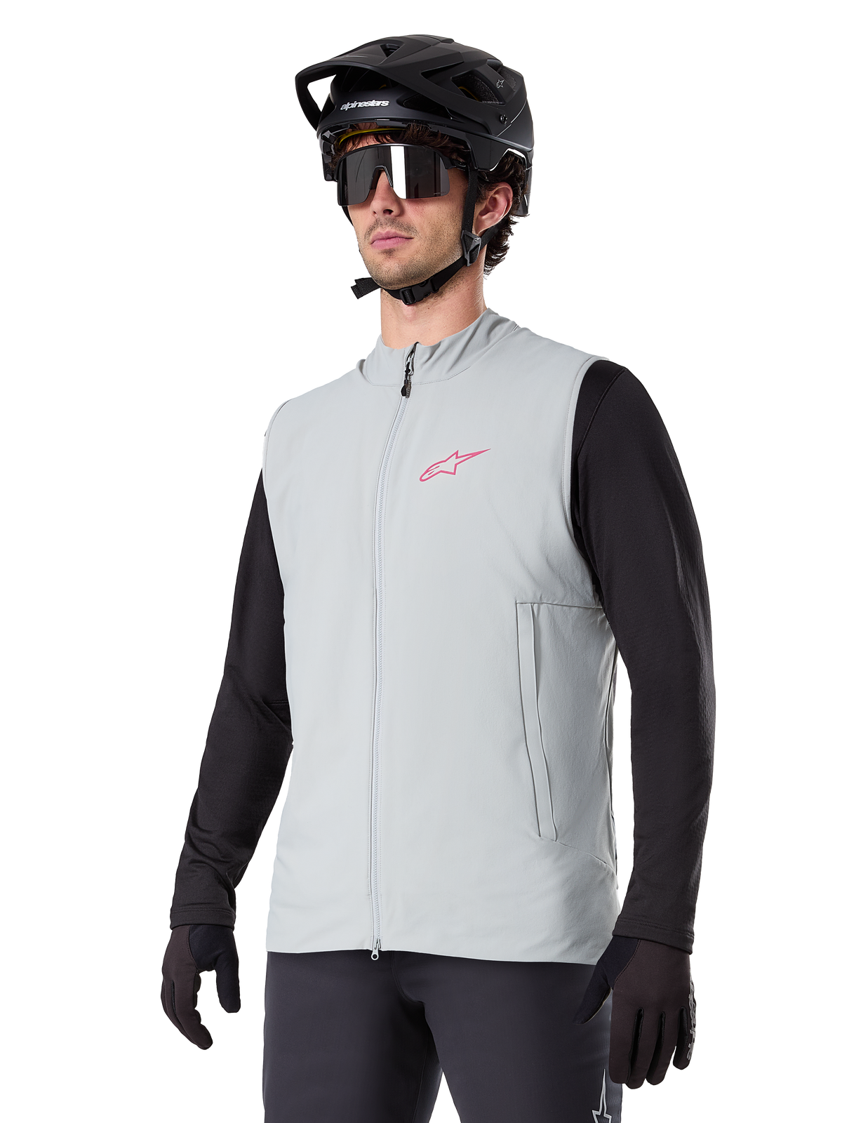 Alpinestars A-Dura Thermal Vest, Titanium Gray, cycling insulated vest, worn over a black long-sleeve shirt with a black mountain bike helmet and gloves, featuring a pink chest logo and vertical zippered side pockets