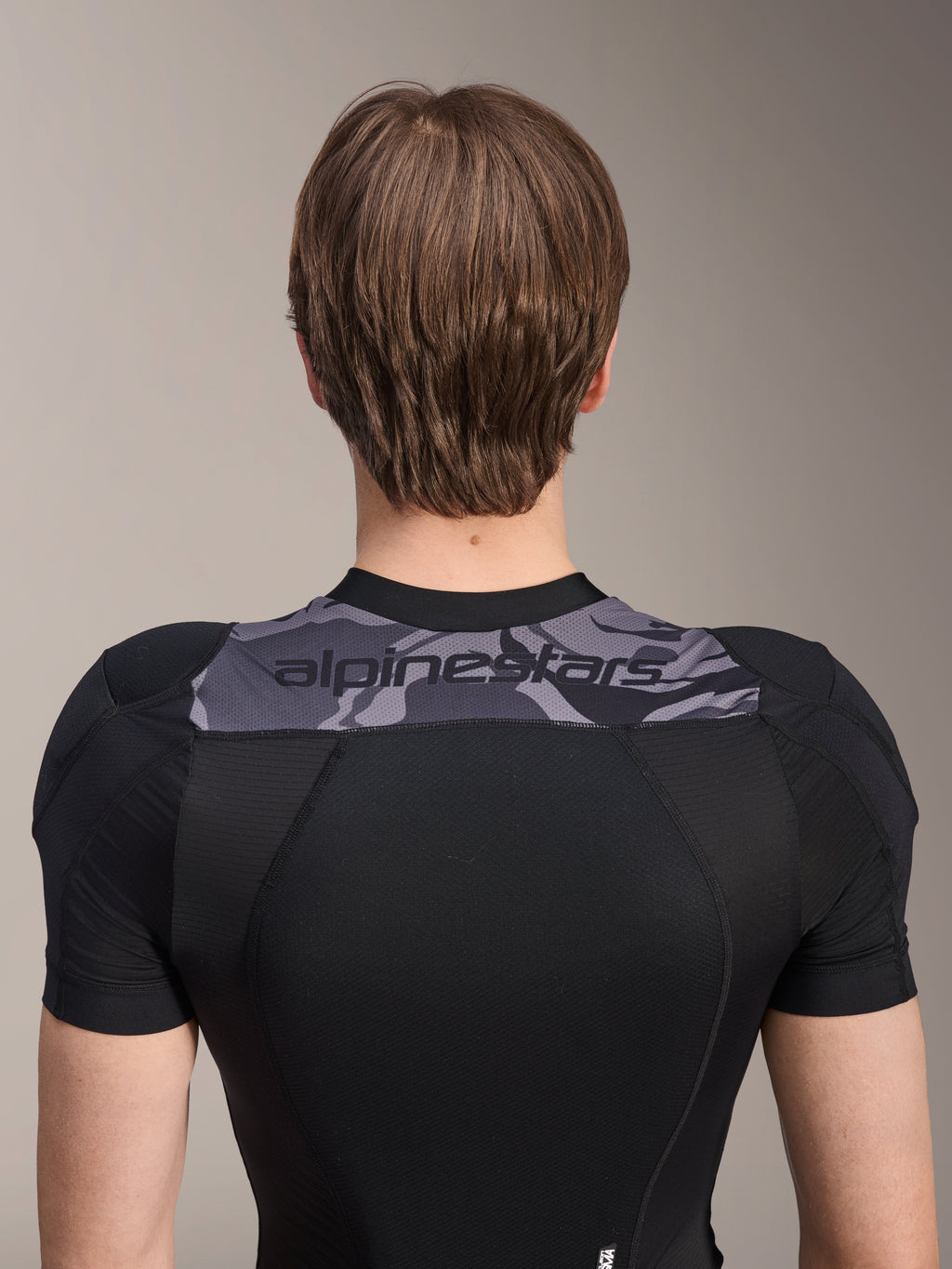 Alpinestars A-Motion Plasma Protection Jacket - Short Sleeve, Back view of upper torso, Black with Grey Camo panel across shoulders featuring Alpinestars logo, breathable stretch mesh construction for MTB protection