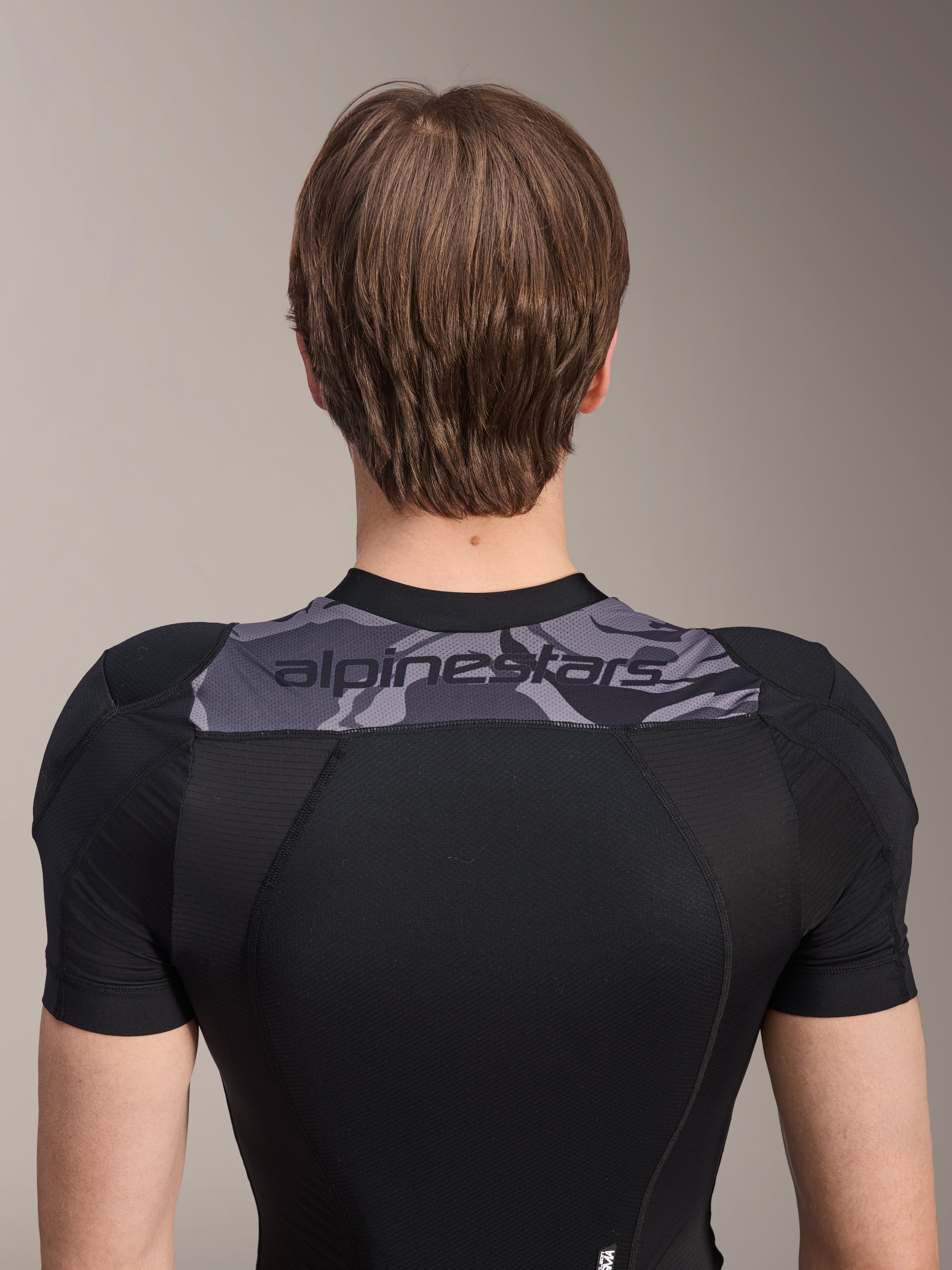 Alpinestars A-Motion Plasma Protection Jacket - Short Sleeve, Back view of upper torso, Black with Grey Camo panel across shoulders featuring Alpinestars logo, breathable stretch mesh construction for MTB protection