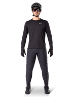 Alpinestars A-Dura Thermo-Hose, Schwarz, getragen von einem Fahrer in kompletter Mountainbike-Ausrüstung einschließlich eines schwarzen Langarmtrikots, Helms und Sonnenbrille, strapazierfähige Hose mit regulärer Passform für Trailfahrten bei kaltem Wetter