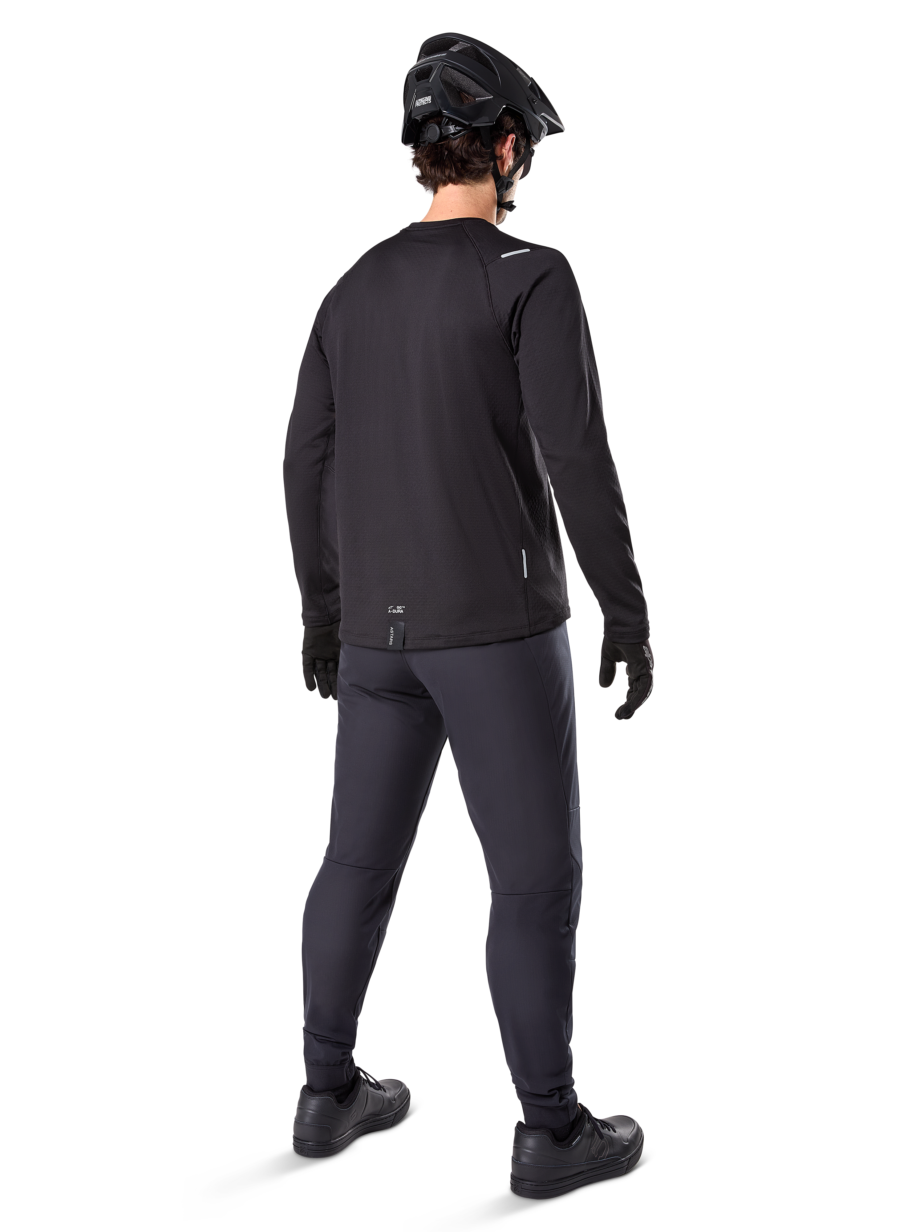 Alpinestars A-Dura Thermo-Hose, Mountainbike-Hose, Schwarz, Rückansicht mit passendem Langarm-Trikot, schwarzem MTB-Helm und Handschuhen, technische Fahrradausrüstung für kaltes Wetter