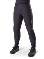 Alpinestars A-Dura Thermo-Hose, schwarze Mountainbike-Hose, getragen mit schwarzen Radschuhen, mit Ratschenverschluss am Bund, kleinem weißem Logo auf dem Oberschenkel, schmal zulaufende Passform für Fahrten bei kaltem Wetter
