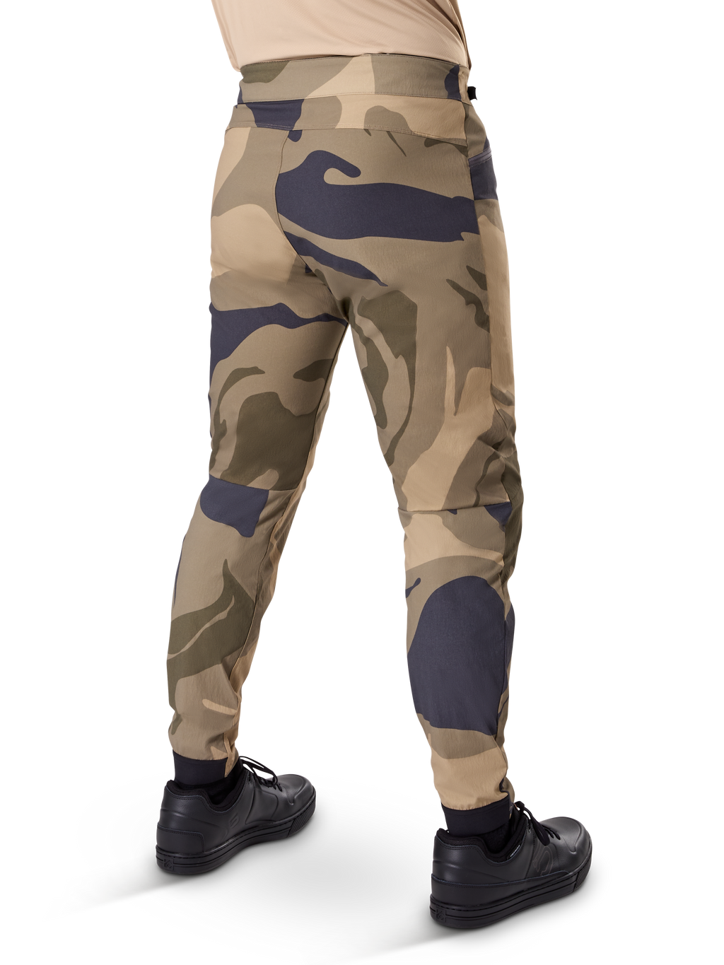 Alpinestars A-Dura Camo Hose, MTB-Hose, braunes Camouflage-Muster mit beigen und dunkelgrauen Akzenten, Rückansicht mit schwarzen Sneakern, schmal zulaufende Beine und elastische Bündchen, strapazierfähiger 2-Wege-Stretchstoff für Mountainbiking