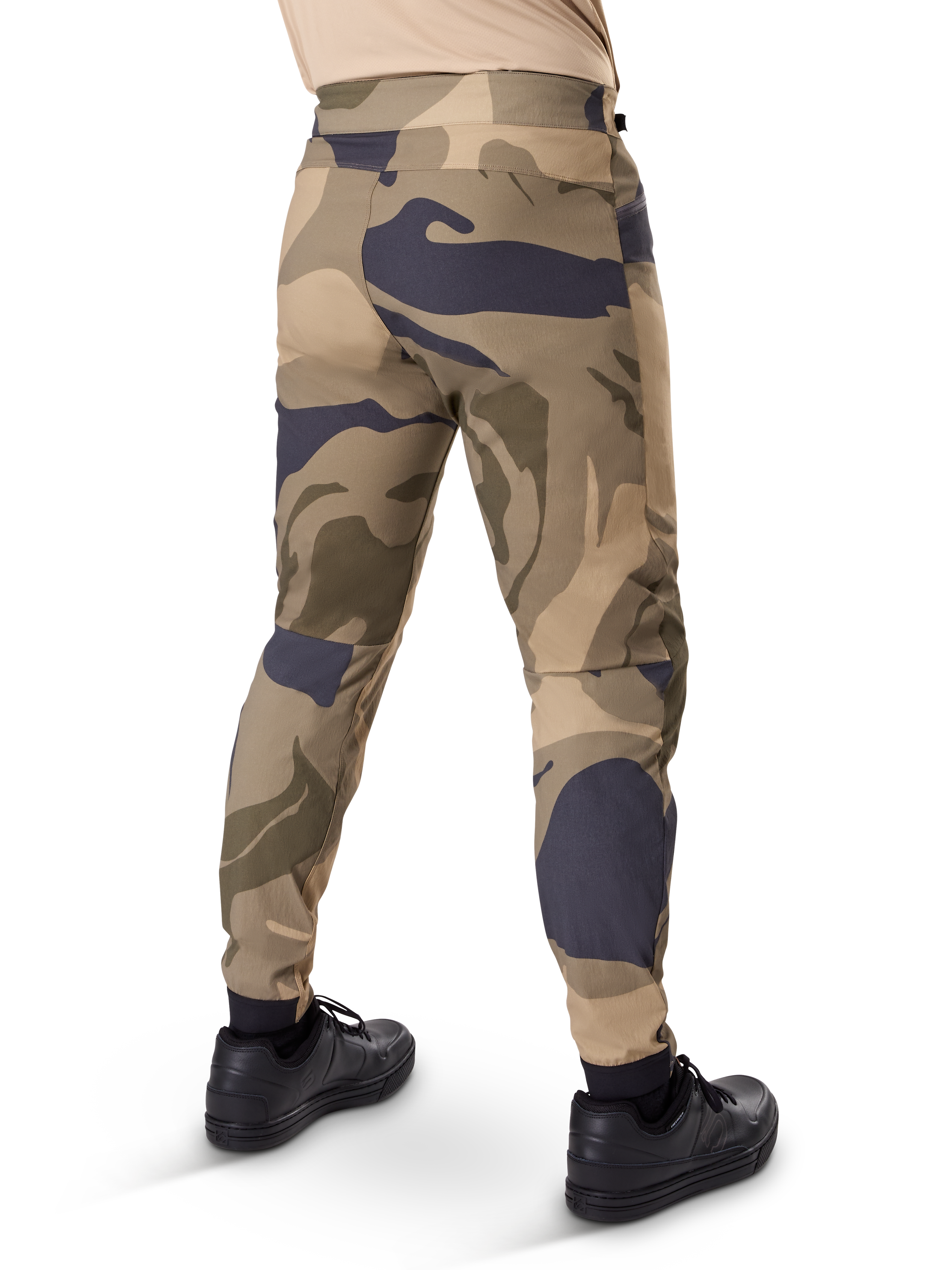 Alpinestars A-Dura Camo Hose, MTB-Hose, braunes Camouflage-Muster mit beigen und dunkelgrauen Akzenten, Rückansicht mit schwarzen Sneakern, schmal zulaufende Beine und elastische Bündchen, strapazierfähiger 2-Wege-Stretchstoff für Mountainbiking