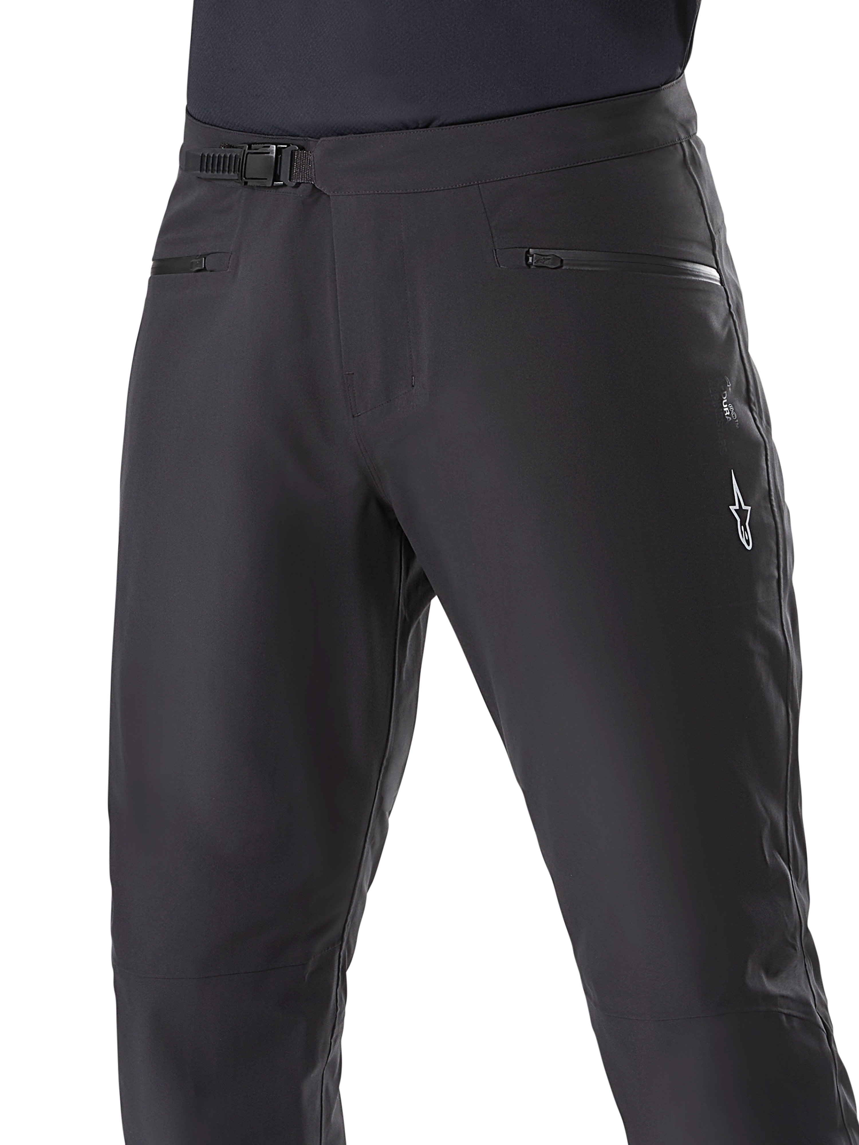Alpinestars A-Dura wasserdichte Hose, MTB-Hose, Schwarz, Nahaufnahme der Taille mit Ratschensystem und Reißverschlusstaschen, weißes Alpinestars-Logo am Oberschenkel, strapazierfähiges Textil für Fahrten auf nassen Trails