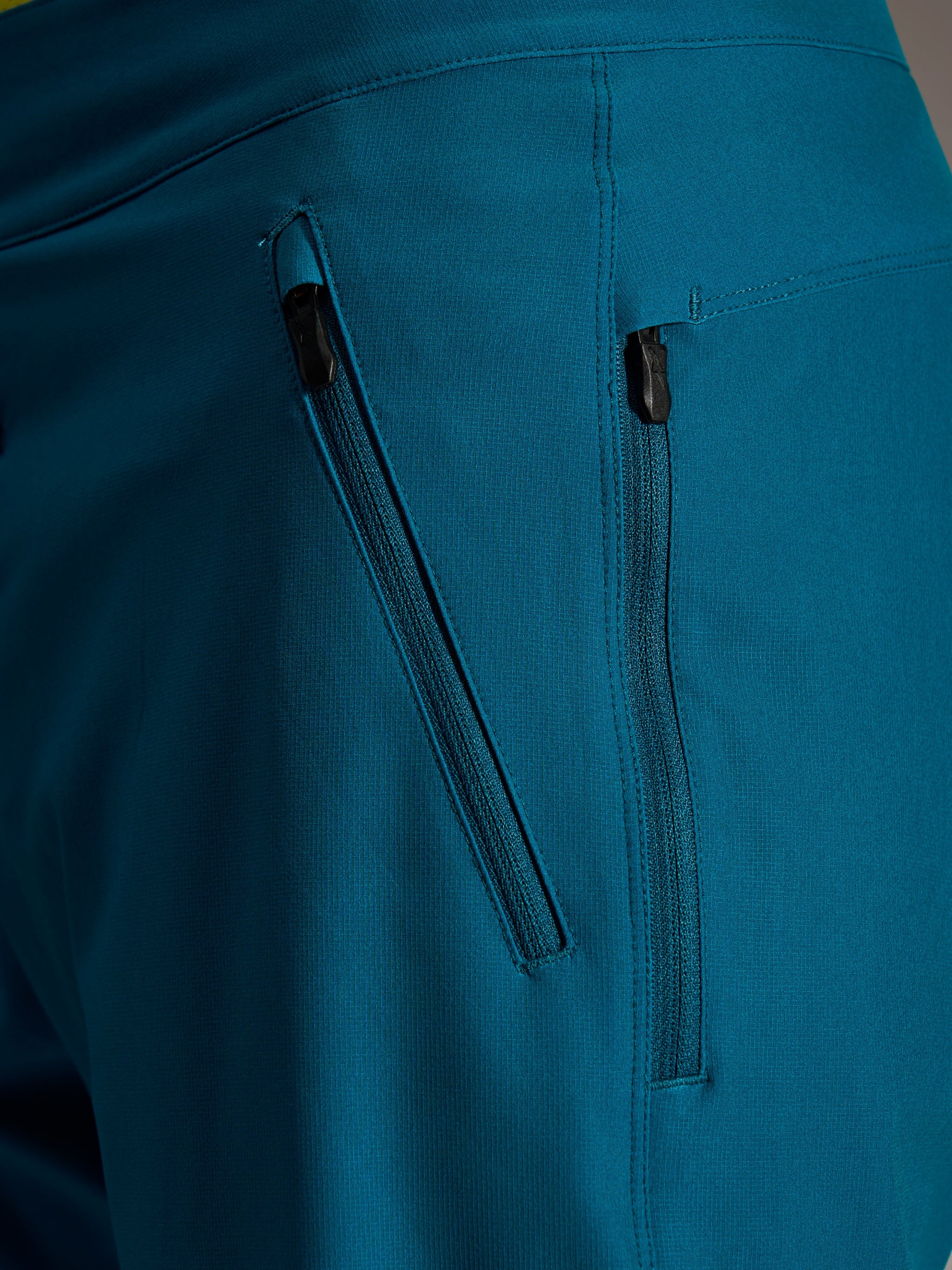 Dual zippered side pockets on Blue Green Alpinestars A-Dura Ride Shorts, featuring durable 4-way stretch woven fabric.