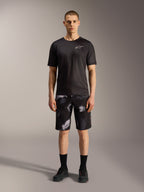 Alpinestars A-Dura Ride Shorts in Black Camo, kombiniert mit einem schwarzen Performance-Shirt für MTB-Vielseitigkeit.