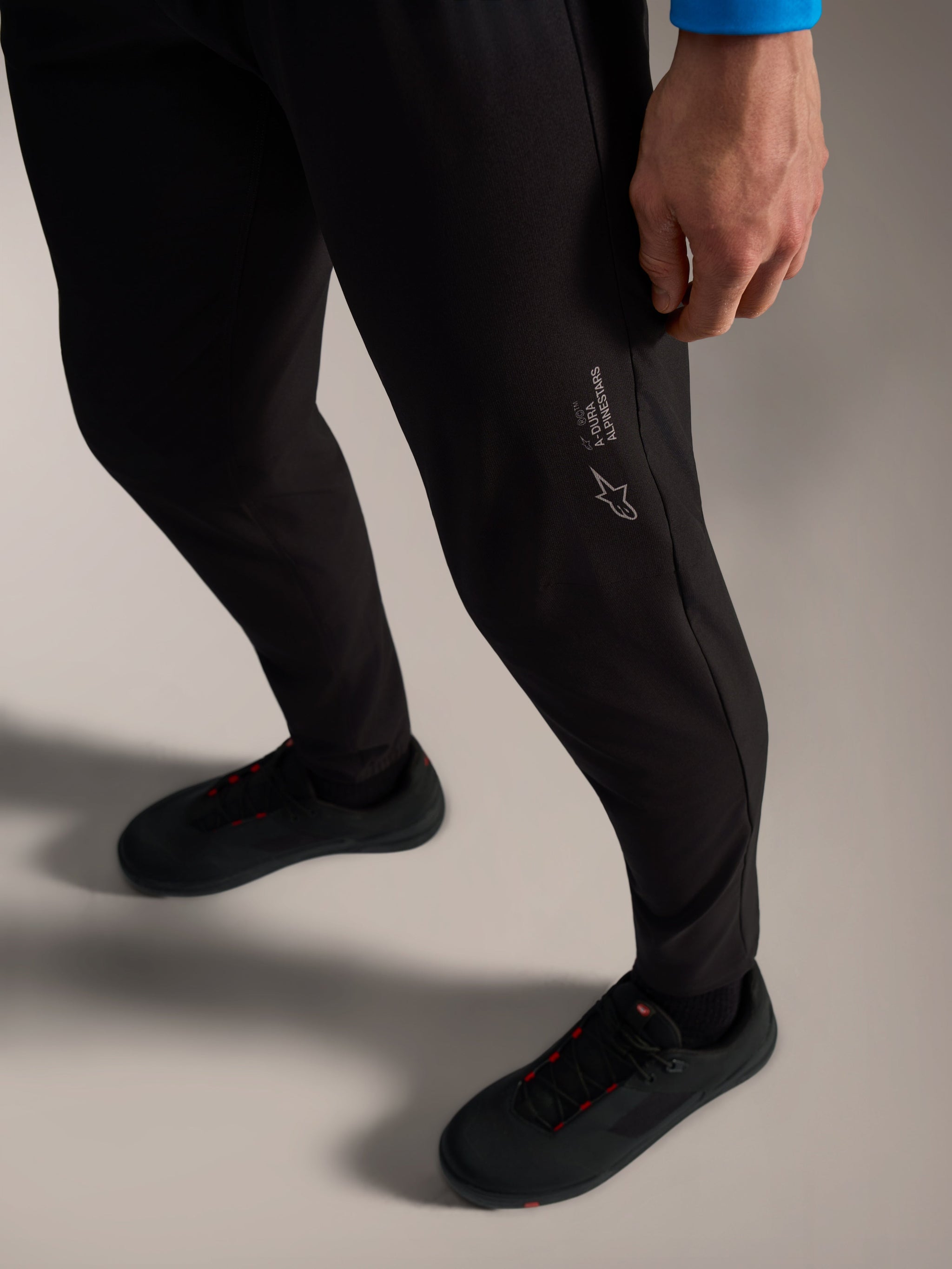 Black A-Dura Ride Pants with Alpinestars logo branding, featuring flexible 4-way stretch fabric for MTB performance.
