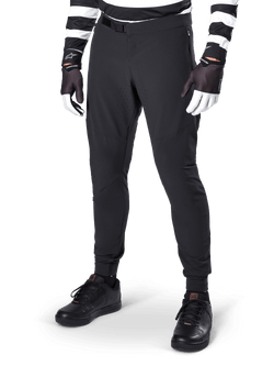 Alpinestars A-Aria Elite Pants, Black Mountain Bike Pants, featuring laser-cut ventilation on thighs and magnetic buckle closure, worn with black and white striped jersey and gloves, performance MTB gear for off-road cycling