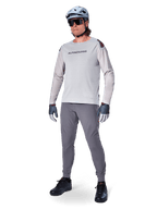 Alpinestars A-Aria Elite Hose, dunkelgraue MTB-Hose, getragen von einem Fahrer mit hellgrauem Langarmtrikot und grauem Helm, mit lasergeschnittener Belüftung an den Oberschenkeln und einer schmal zulaufenden Performance-Passform für das Mountainbiken.