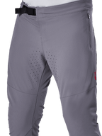 Alpinestars A-Aria Elite Hose, MTB-Radhose, Dunkelgrau, Nahaufnahme mit Magnetverschluss, Seitentasche mit Reißverschluss und lasergeschnittenen Belüftungsperforationen an den Innenseiten der Oberschenkel für Trailriding-Performance.