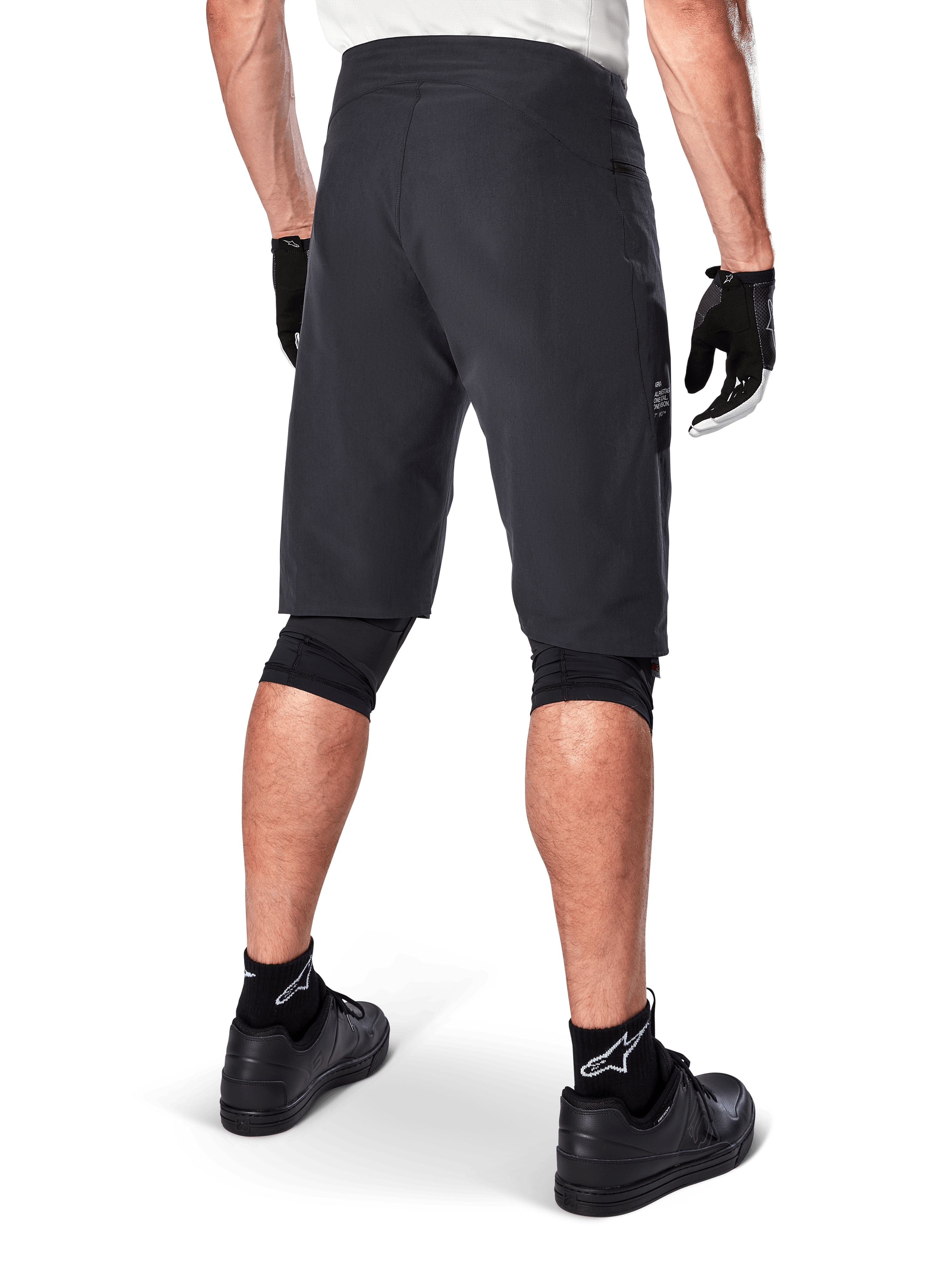 Alpinestars A-Aria Shorts, Mountain Bike Shorts, Black, rear view showing performance fit and clean design, worn with black gloves and socks featuring the white Astars logo, technical cycling apparel for off-road riding