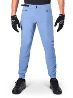 Alpinestars A-Dura Hose, MTB-Hose, Infinity Blue, hellblaue Mountainbike-Hose mit doppeltem Druckknopfverschluss und Reißverschlusstaschen, getragen mit schwarzen Handschuhen und schwarzen Schuhen, reguläre Passform mit elastischen Bündchen