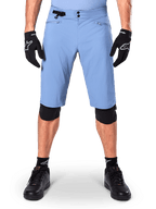 Alpinestars A-Dura Shorts, Mountainbike-Shorts in Infinity Blue, getragen mit schwarzen Handschuhen und Knieschonern, mit doppeltem Druckknopfverschluss und seitlichem Taillenversteller, Performance-MTB-Ausrüstung