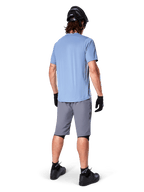 Alpinestars A-Dura Shorts, dunkelgraue MTB-Shorts, Rückansicht, getragen mit einem hellblauen Kurzarmtrikot, schwarzem Mountainbike-Helm, schwarzen Handschuhen, Socken und Schuhen, funktionelle und strapazierfähige Ausrüstung für den Offroad-Radsport